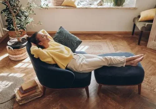 top-view-of-happy-woman-keeping-eyes-closed-while-relaxing-in-comfortable-chair-at-home-photo
